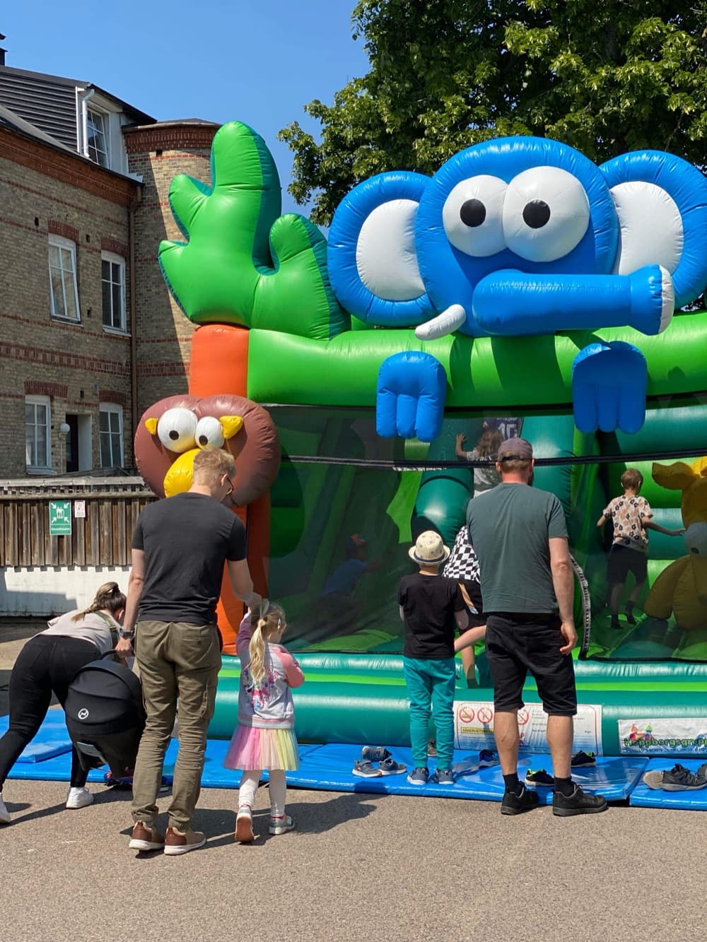 Barn och föräldrar vid hoppborgen på Barnens dag